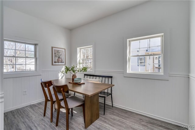 dining room with a wainscoted wall and wood finished floors