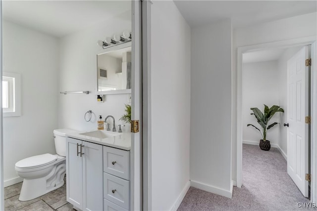 bathroom featuring vanity, toilet, and baseboards