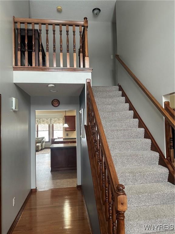 stairway with baseboards and wood finished floors