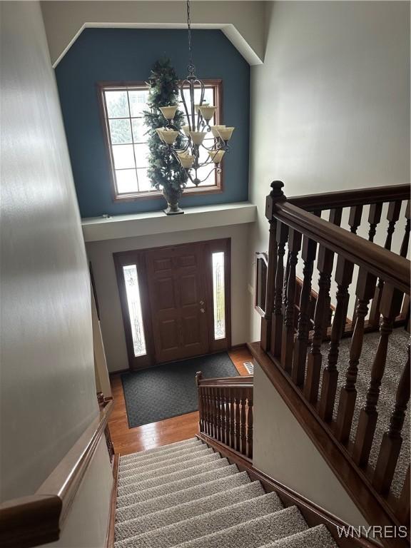 foyer entrance featuring a high ceiling, a chandelier, and wood finished floors