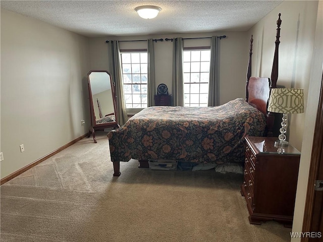 bedroom with baseboards, a textured ceiling, and light colored carpet