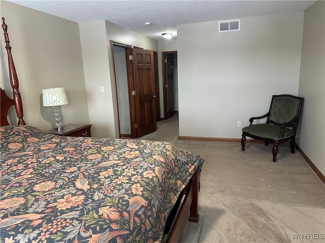 bedroom with a textured ceiling, carpet, visible vents, and baseboards