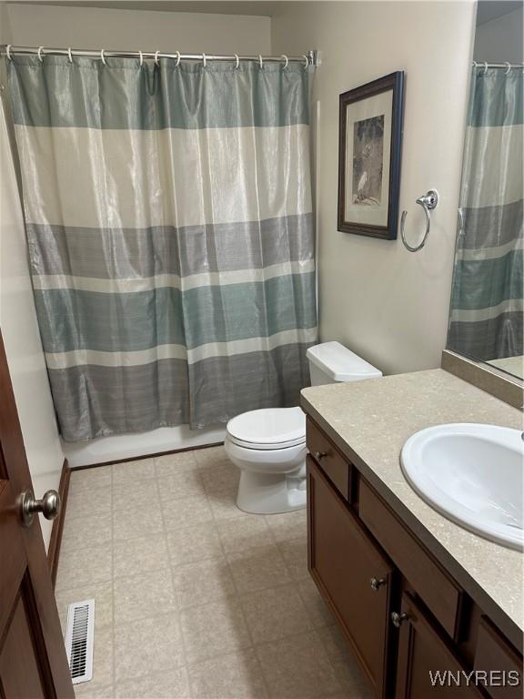 bathroom featuring toilet, a shower with curtain, visible vents, and vanity