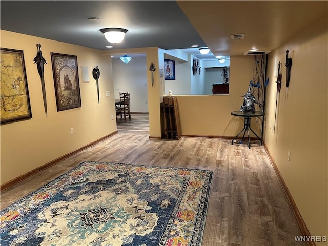 interior space with baseboards, visible vents, and wood finished floors