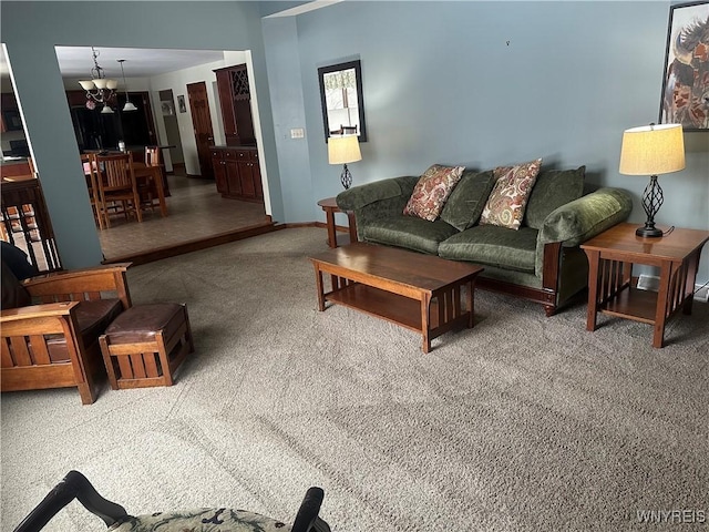 carpeted living room featuring an inviting chandelier and baseboards