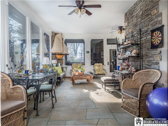 sunroom / solarium featuring a ceiling fan