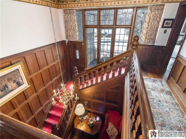 interior space with a chandelier, wainscoting, and wood finished floors