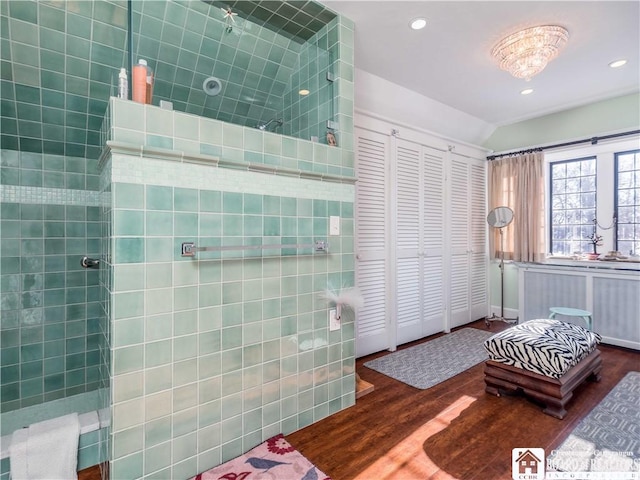 bathroom with lofted ceiling, a walk in shower, and wood finished floors