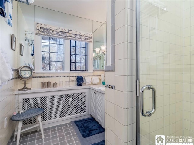 bathroom with a shower stall and tile patterned floors