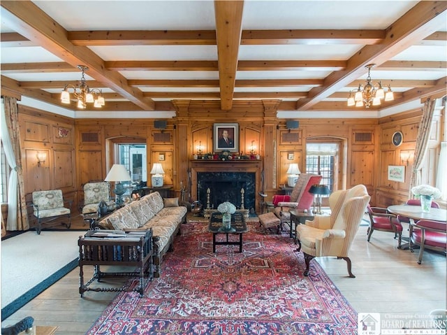 living room featuring a chandelier, a fireplace, and beam ceiling