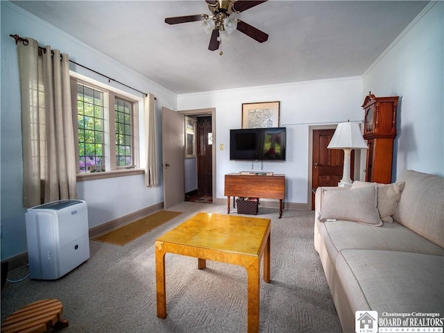 living area with ceiling fan, baseboards, crown molding, and carpet flooring