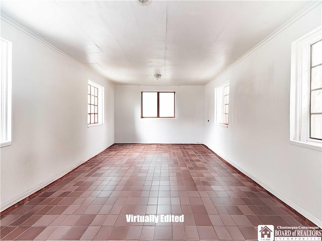 empty room featuring ornamental molding and dark tile patterned floors