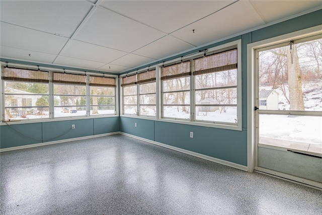 unfurnished sunroom with a drop ceiling and a healthy amount of sunlight