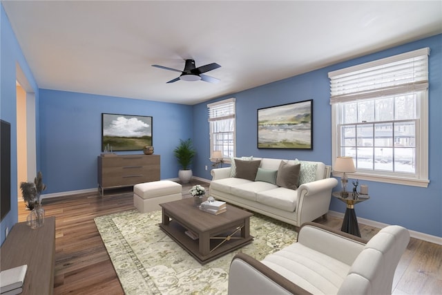 living area with a ceiling fan, baseboards, and wood finished floors