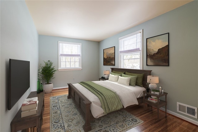 bedroom with visible vents, baseboards, and wood finished floors