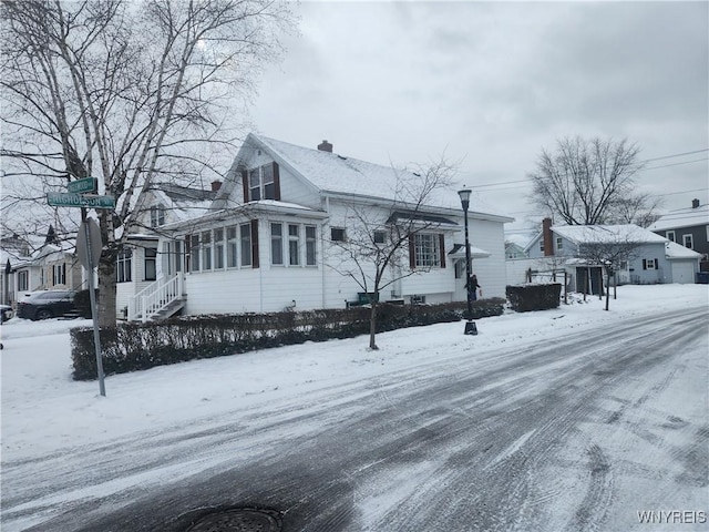 view of snowy exterior featuring a chimney