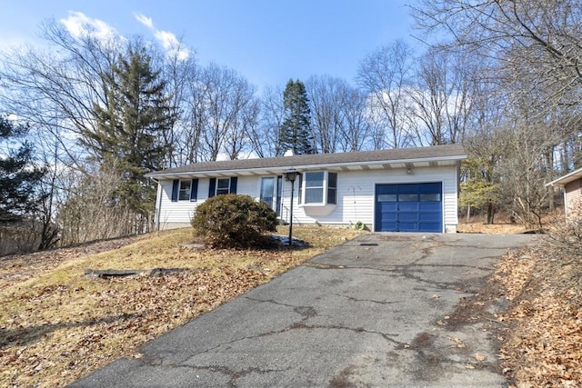 ranch-style home with aphalt driveway and an attached garage