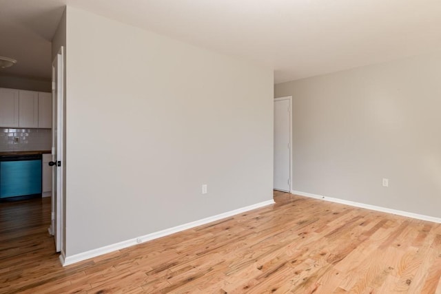 empty room with light wood-style flooring and baseboards