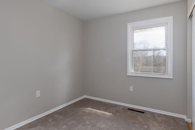 carpeted empty room with visible vents and baseboards