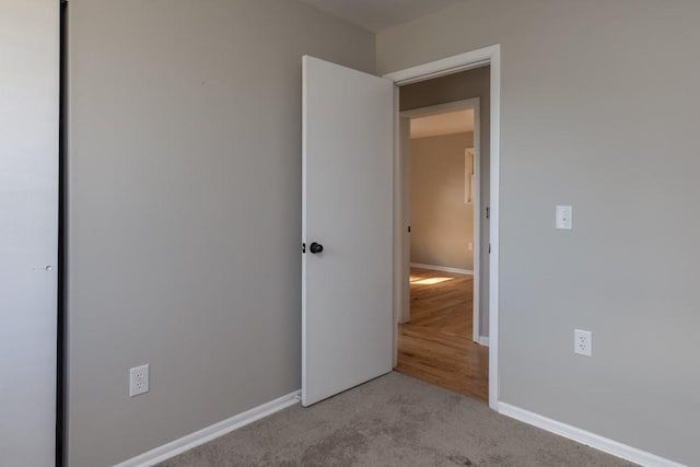 unfurnished bedroom featuring a closet, carpet, and baseboards