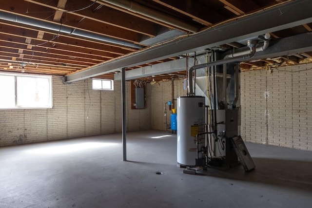 basement featuring water heater, brick wall, electric panel, and heating unit