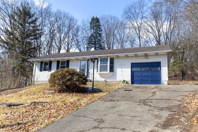 single story home with driveway and an attached garage