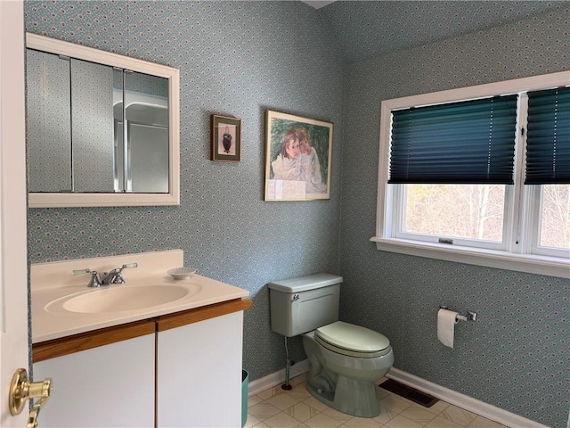 bathroom with baseboards, visible vents, vanity, and toilet