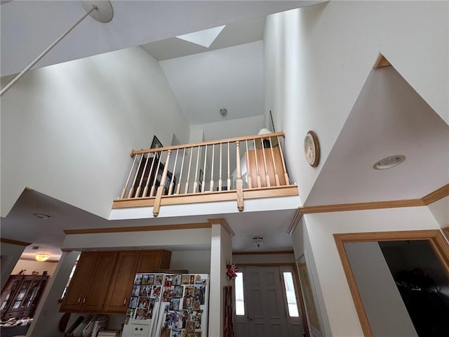 interior space featuring a towering ceiling and a skylight