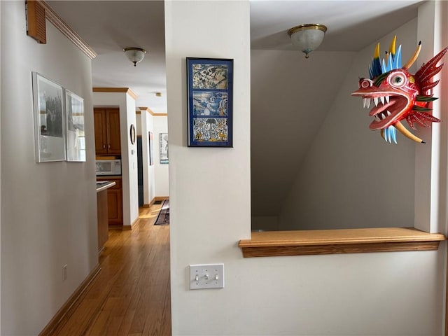 corridor with baseboards and wood finished floors