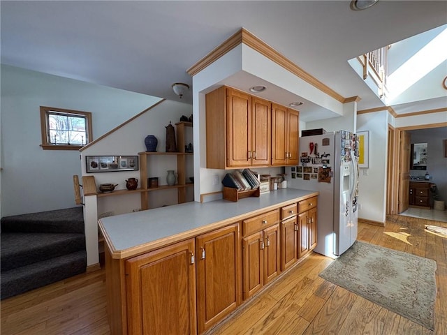 kitchen with light wood finished floors, brown cabinetry, and light countertops