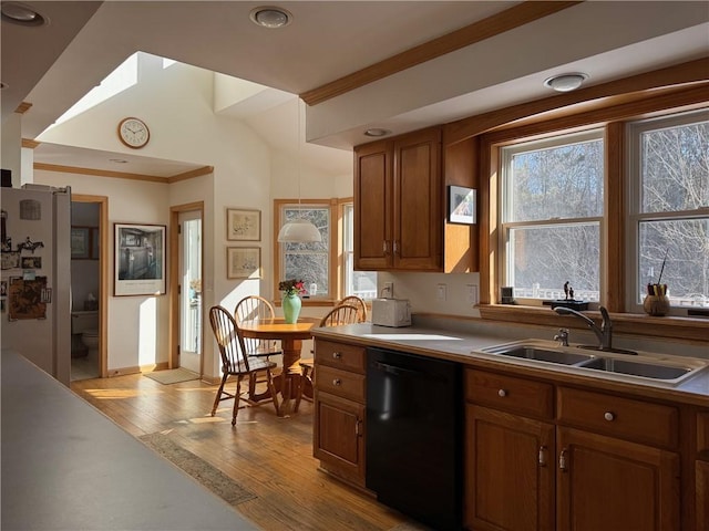 kitchen with brown cabinets, dishwasher, hardwood / wood-style floors, and a sink