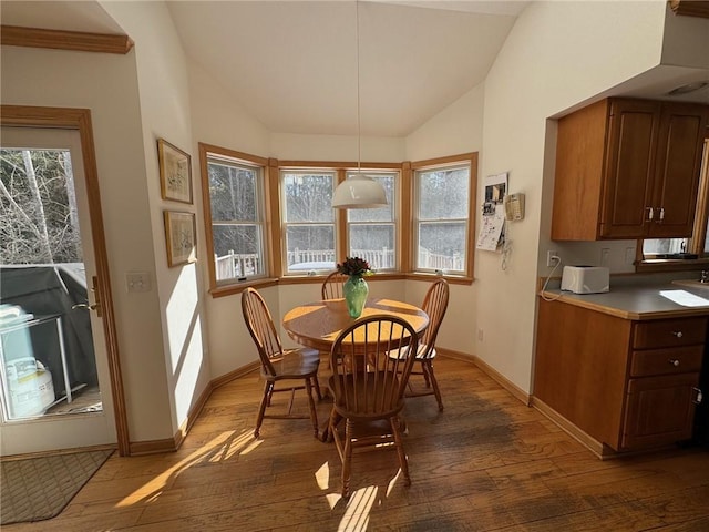 dining space with lofted ceiling, baseboards, and hardwood / wood-style floors