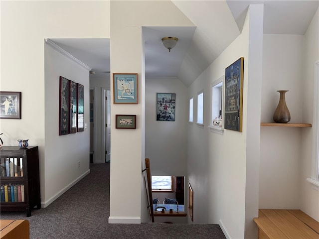 corridor featuring baseboards, vaulted ceiling, carpet flooring, and an upstairs landing