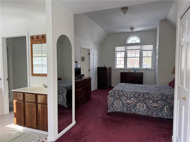 bedroom with carpet floors, vaulted ceiling, and a sink