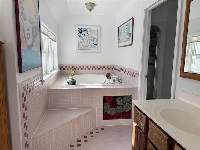 bathroom with tile patterned flooring, a garden tub, and vanity