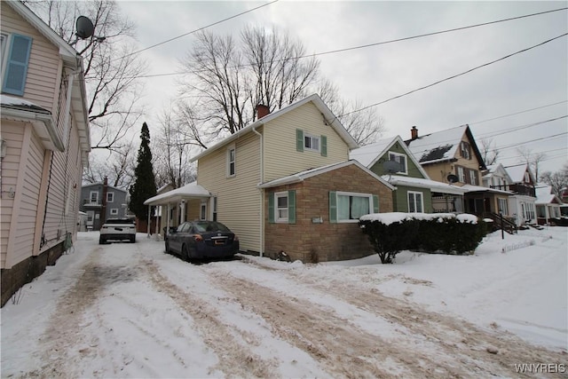 view of snow covered exterior featuring a residential view