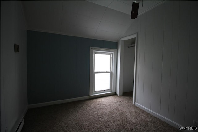 empty room with a ceiling fan, a baseboard radiator, carpet flooring, and vaulted ceiling