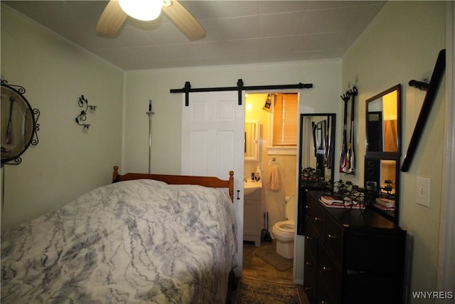 bedroom featuring a barn door and a ceiling fan