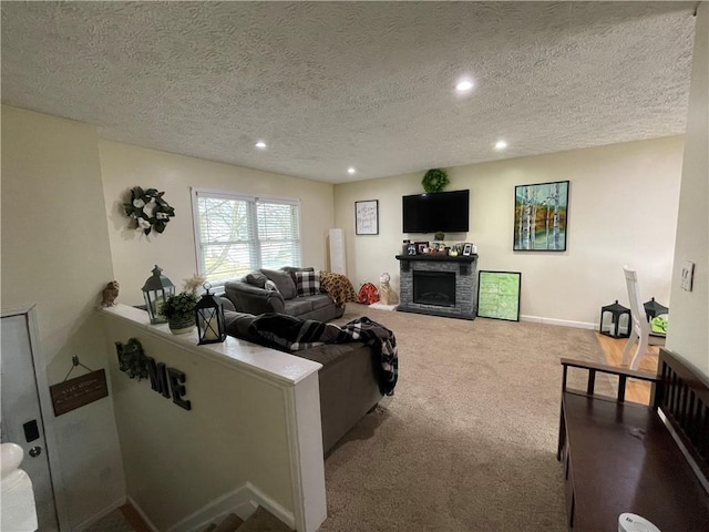 living room with baseboards, carpet, a textured ceiling, a stone fireplace, and recessed lighting