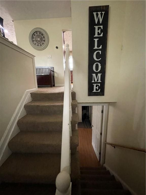 stairway featuring baseboards and wood finished floors