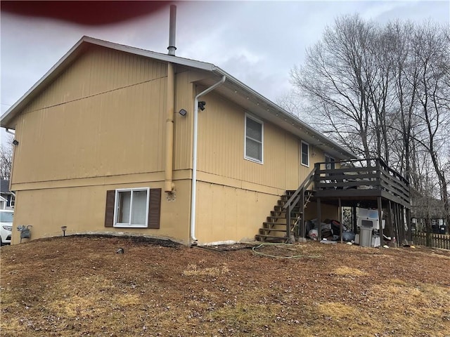 view of property exterior with stairs and a wooden deck