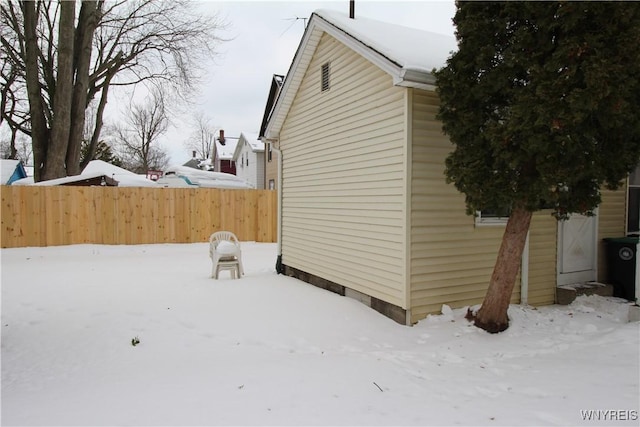 view of snow covered exterior featuring fence