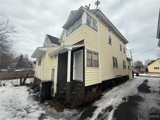 view of home's exterior with entry steps and fence