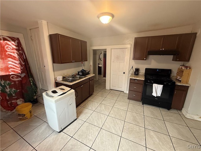 kitchen with light countertops, black gas stove, a sink, dark brown cabinets, and under cabinet range hood