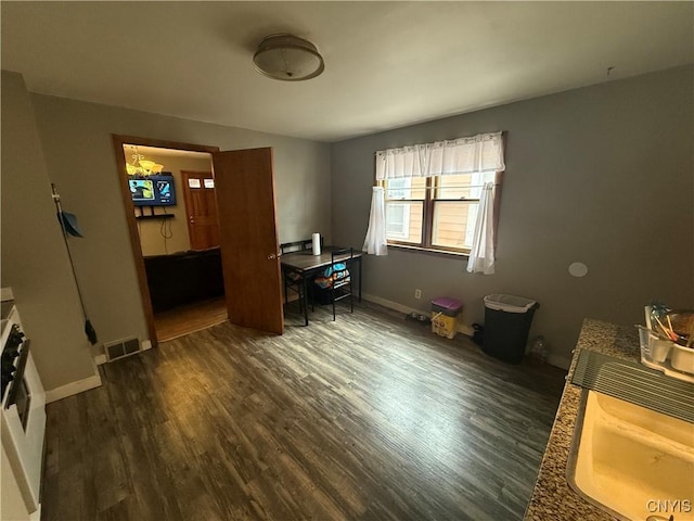 office space with baseboards, visible vents, and dark wood finished floors