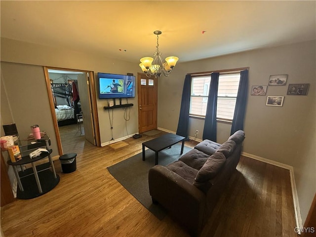 living room with baseboards, an inviting chandelier, and wood finished floors