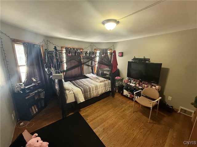 bedroom featuring visible vents and wood finished floors