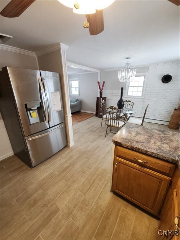 kitchen with ceiling fan with notable chandelier, stainless steel fridge with ice dispenser, ornamental molding, light wood-type flooring, and brown cabinets