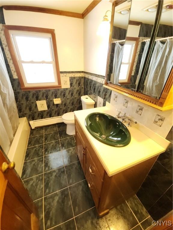 bathroom featuring ornamental molding, a wealth of natural light, tile walls, and vanity