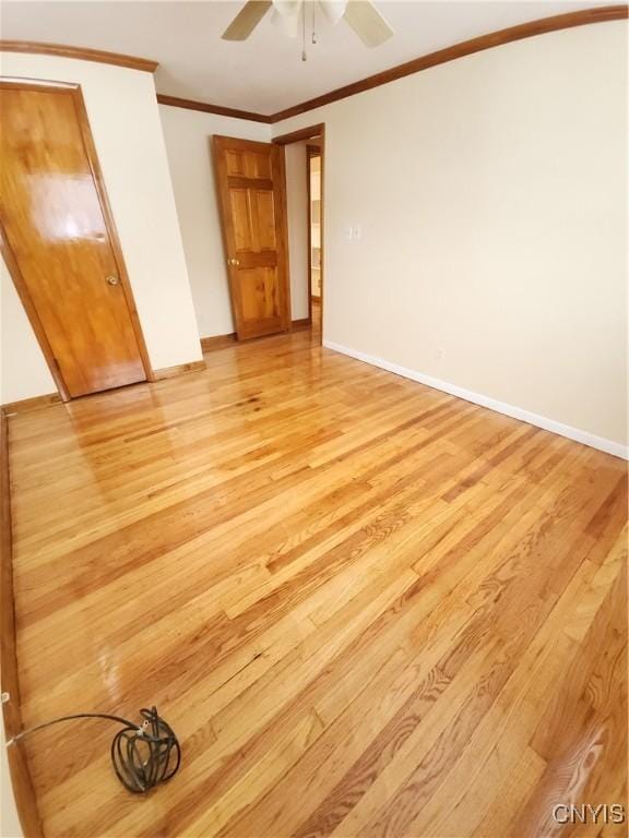 unfurnished bedroom featuring baseboards, crown molding, and light wood finished floors